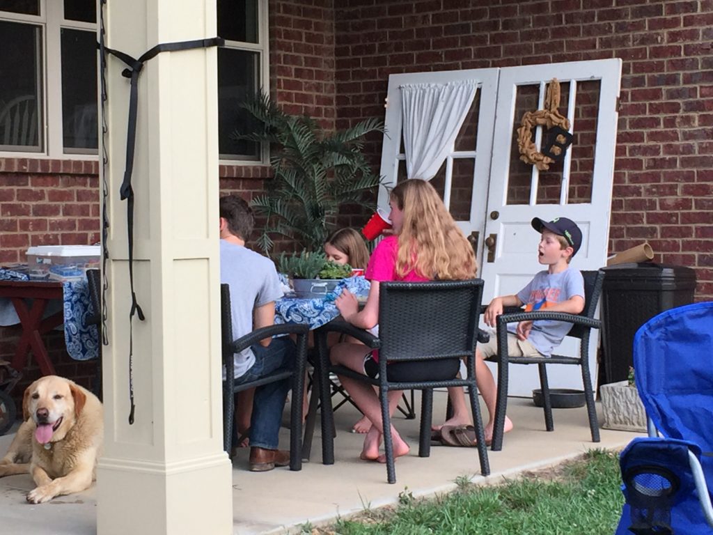 Group of kids sitting outside at a table